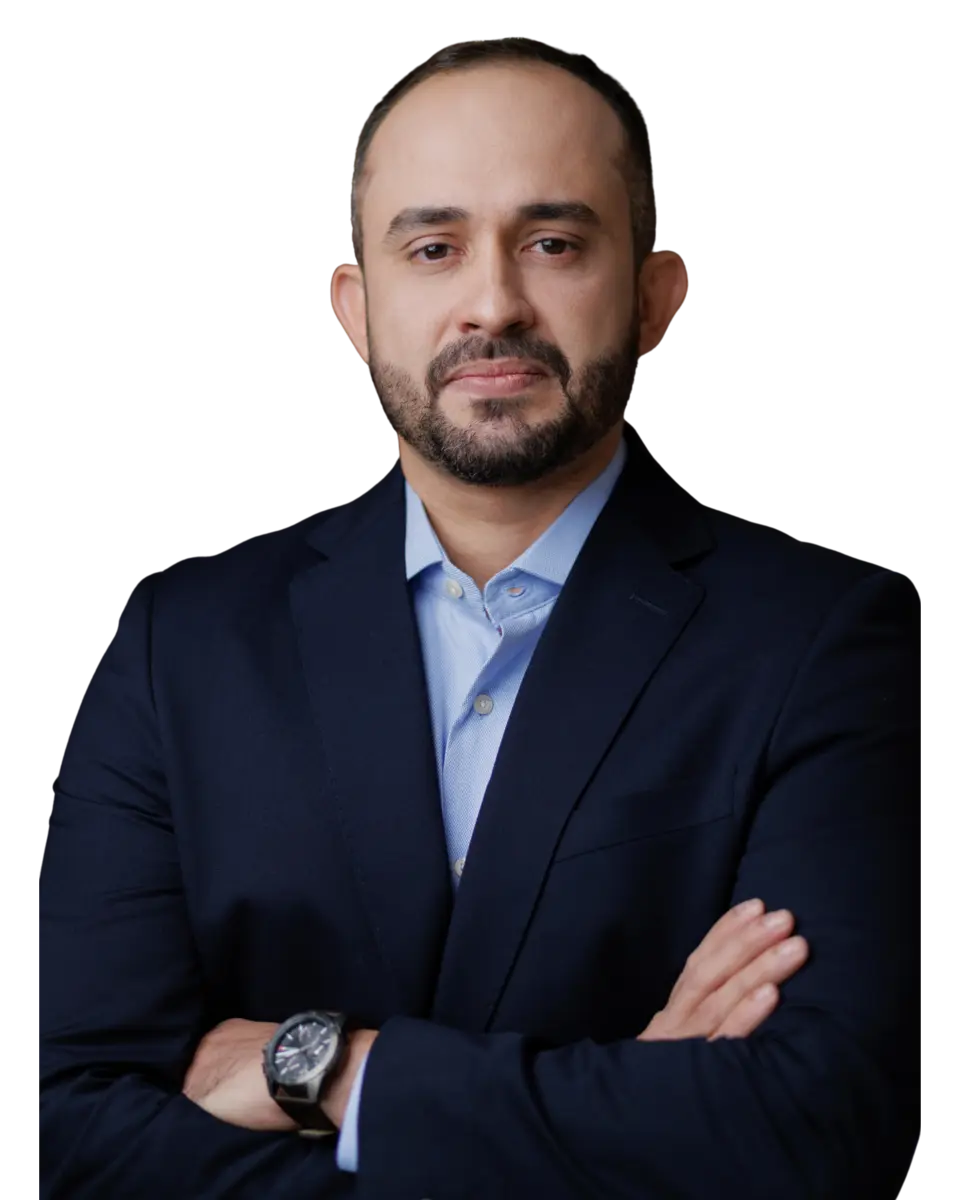 Dr. Tarcísio Andrade de terno, braços cruzados, no consultório
